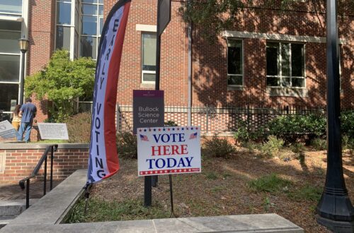 A voting sign in the ground in front of Bullock Science Center