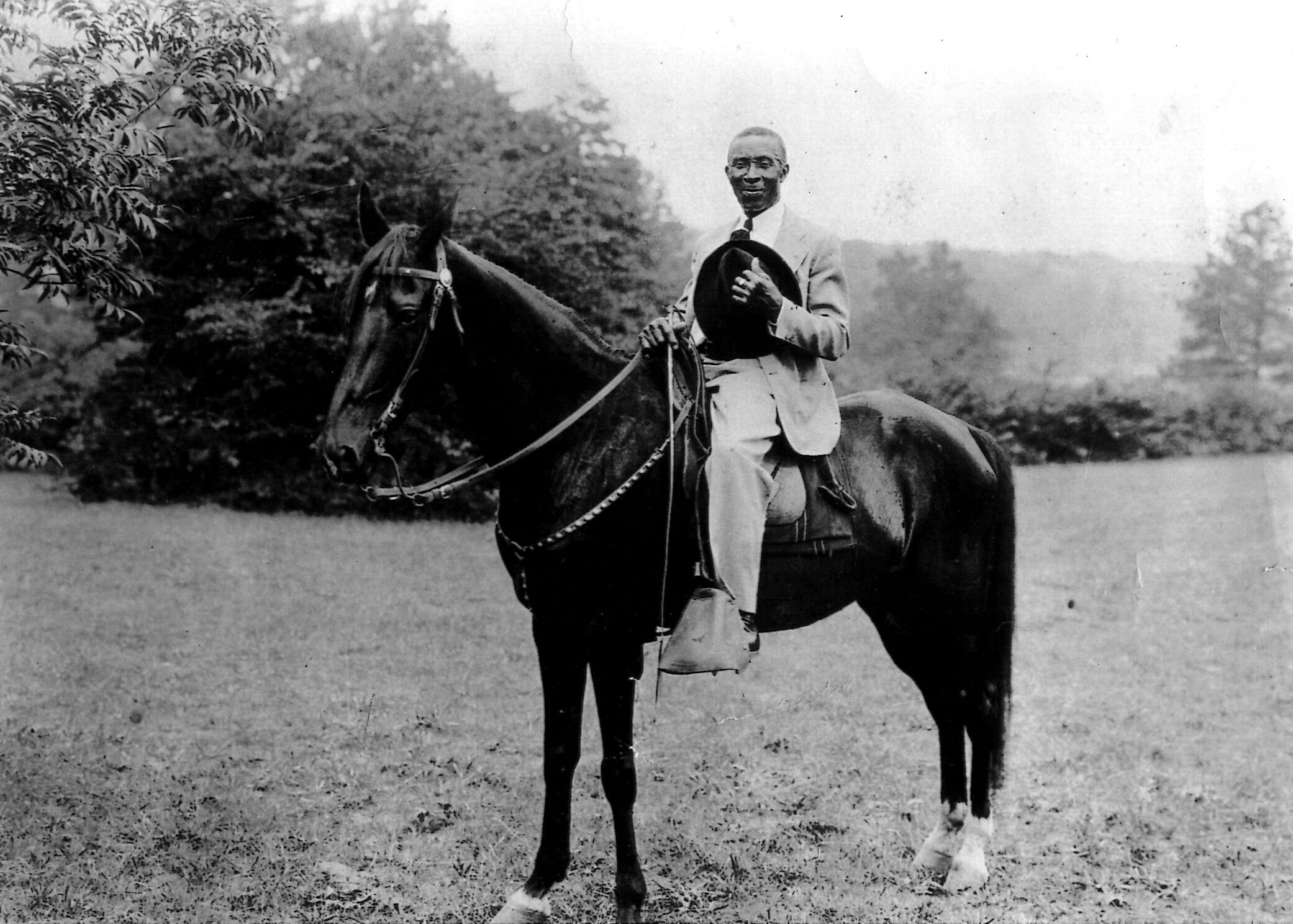 Black and white photo of a man sitting on a horse