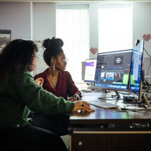 two students use video editing software to craft a project