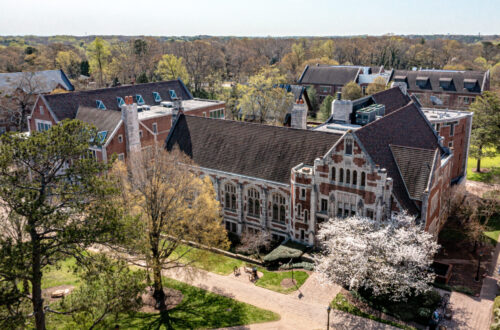 A shot above McCain Library, a gothic brick structure with large windows. Spring buds begin to blossom on the trees