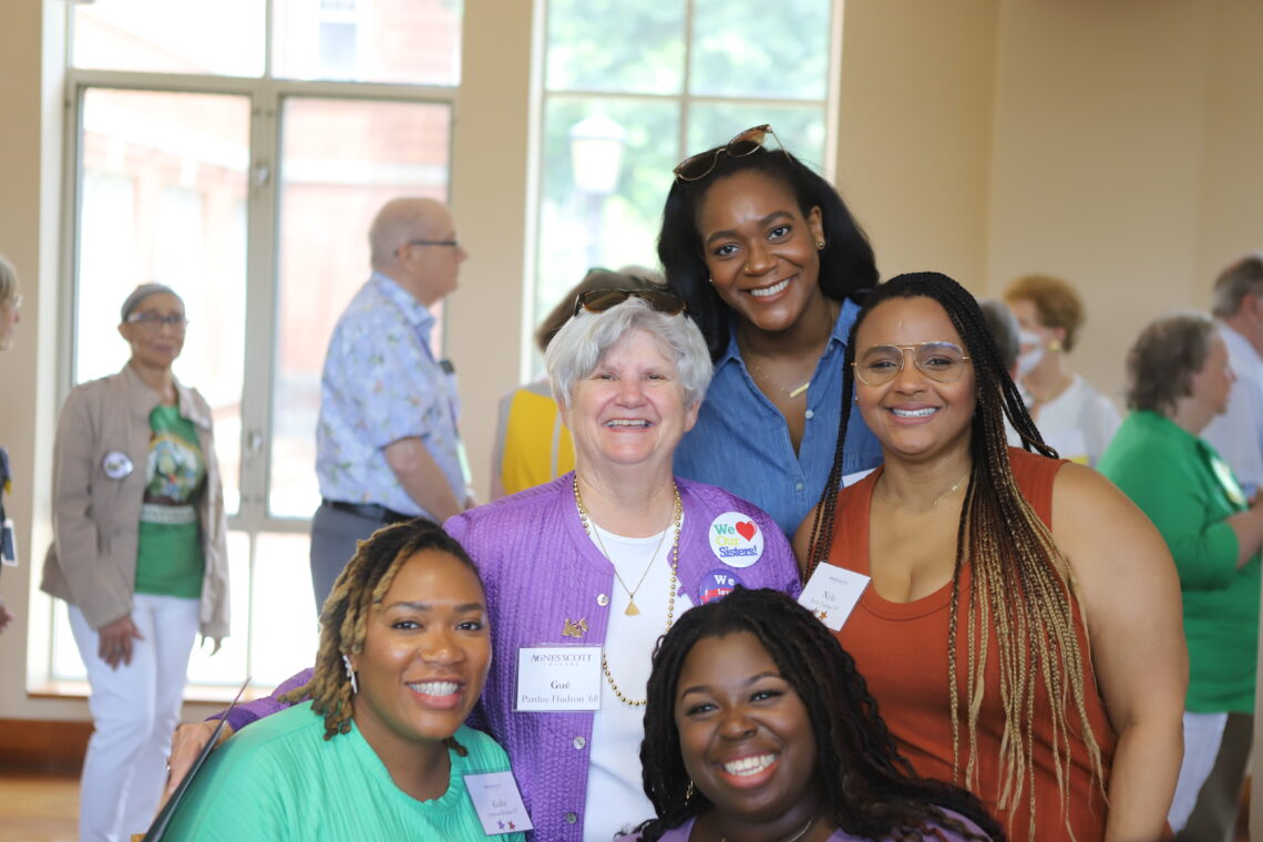 Alumnae and Gue Hudson pose for a photo in Evans Dining Hall
