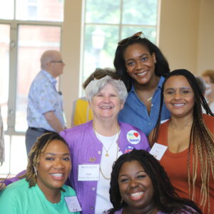 Alumnae and Gue Hudson pose for a photo in Evans Dining Hall
