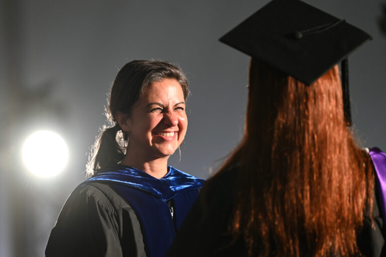 The Academic Dean, Rachel Bowser, smiling at a graduate.