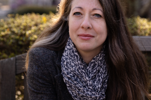 a photo of Nicole Stamant. She has a semi-serious face and leans forward