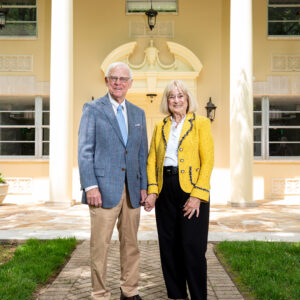A couple stand in front of a well lit building.