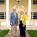 A couple stand in front of a well lit building.