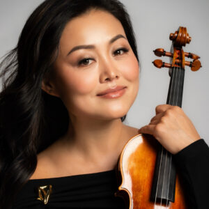 Qiao Chen Solomon holding a violin.