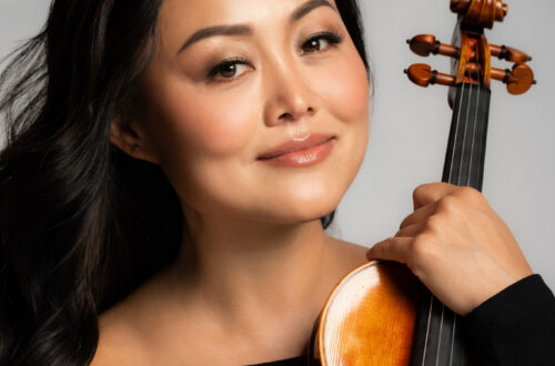 Qiao Chen Solomon holding a violin.